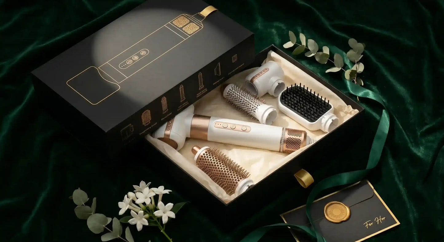 Set of hair care tools including a box, brush, and other accessories on a green fabric background.