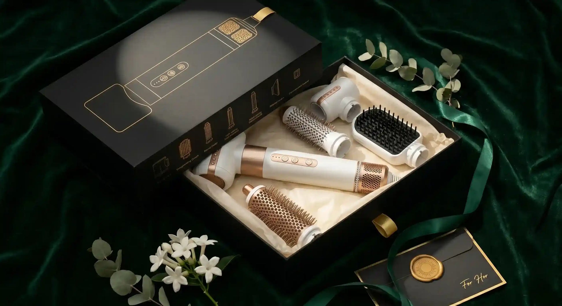 Set of hair care tools including a box, brush, and other accessories on a green fabric background.