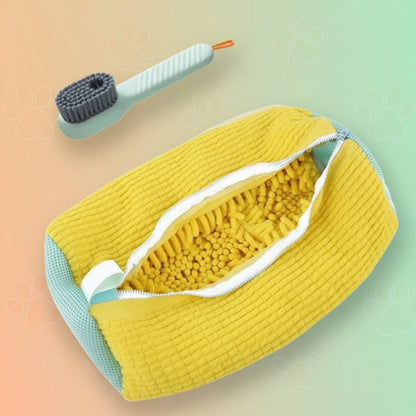 Yellow dog toy with textured surface and green handle on a white background