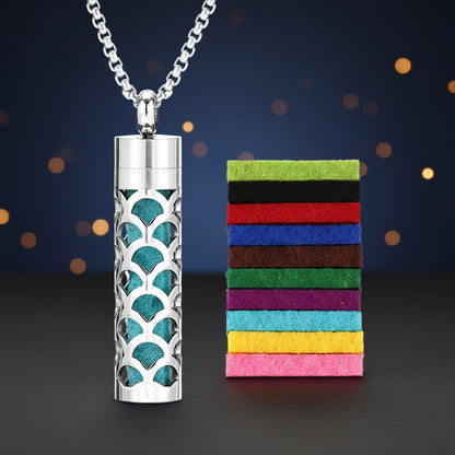 Silver necklace with a decorative pendant next to colorful felt strips on a white background