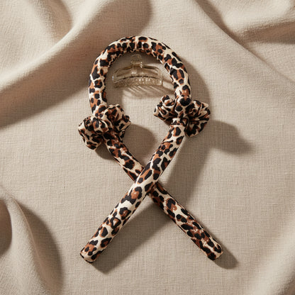 Leopard print dog toy with a metal clip on a white background