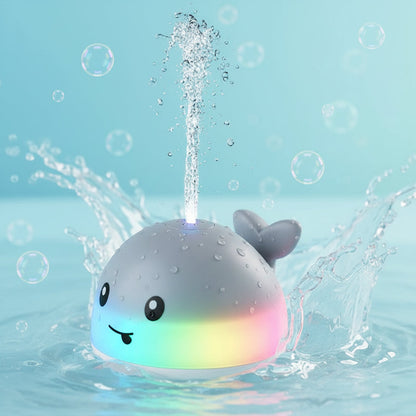 Whale-shaped bath toy with water sprays and colorful lights, child playing with it.