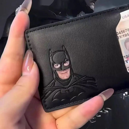 Black leather wallet with a Batman emblem held by a hand.