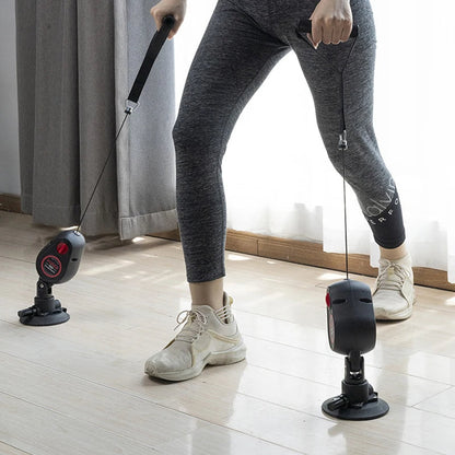 Person using a resistance band exercise device on a wooden floor.