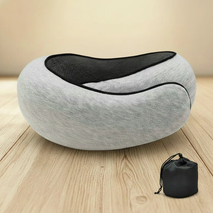 Gray neck pillow with black interior on a wooden floor, accompanied by a black carrying bag.