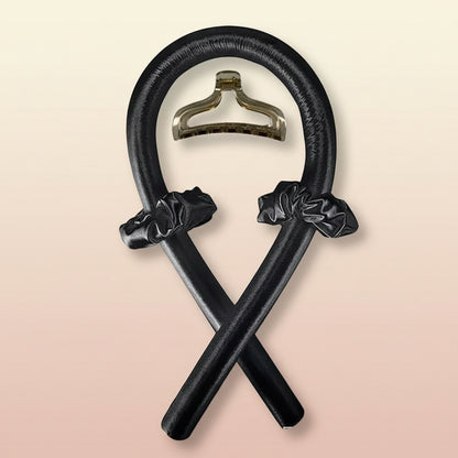 Decorative black metal object with a central hanger on a white background