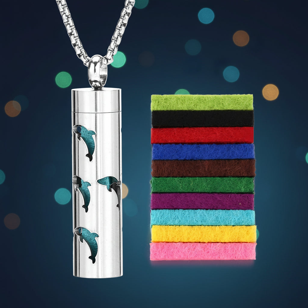 Silver cylindrical pendant with dolphin designs on a white background, accompanied by a colorful felt strip.